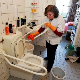 Thuis hulp maakt toilet schoon