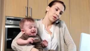foto van vrouw telefonerend met huilend kind op de arm